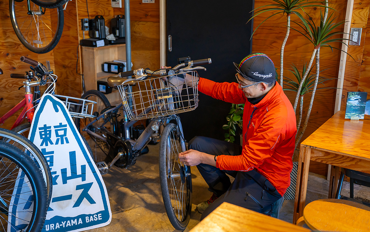 東京裏山ベース店内で自転車を修理するジンケンさんの写真